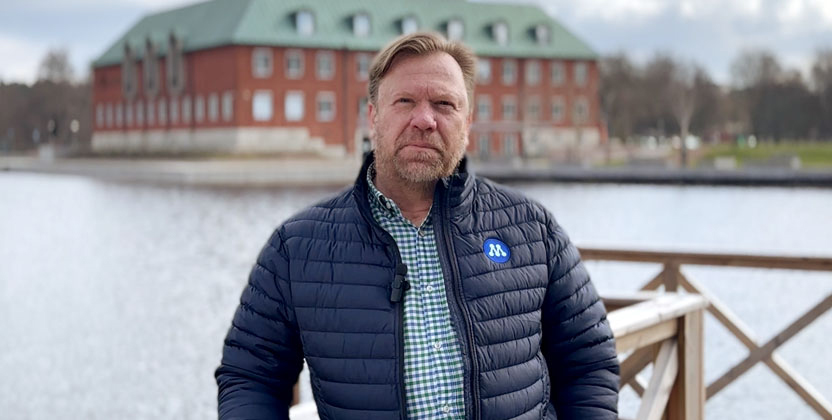 En man fråmför ett vattendrag och en pampig byggnad.