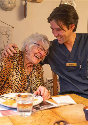 Förskollärare Sandra Rehn utanför byggnad med barn i bakgrunden.