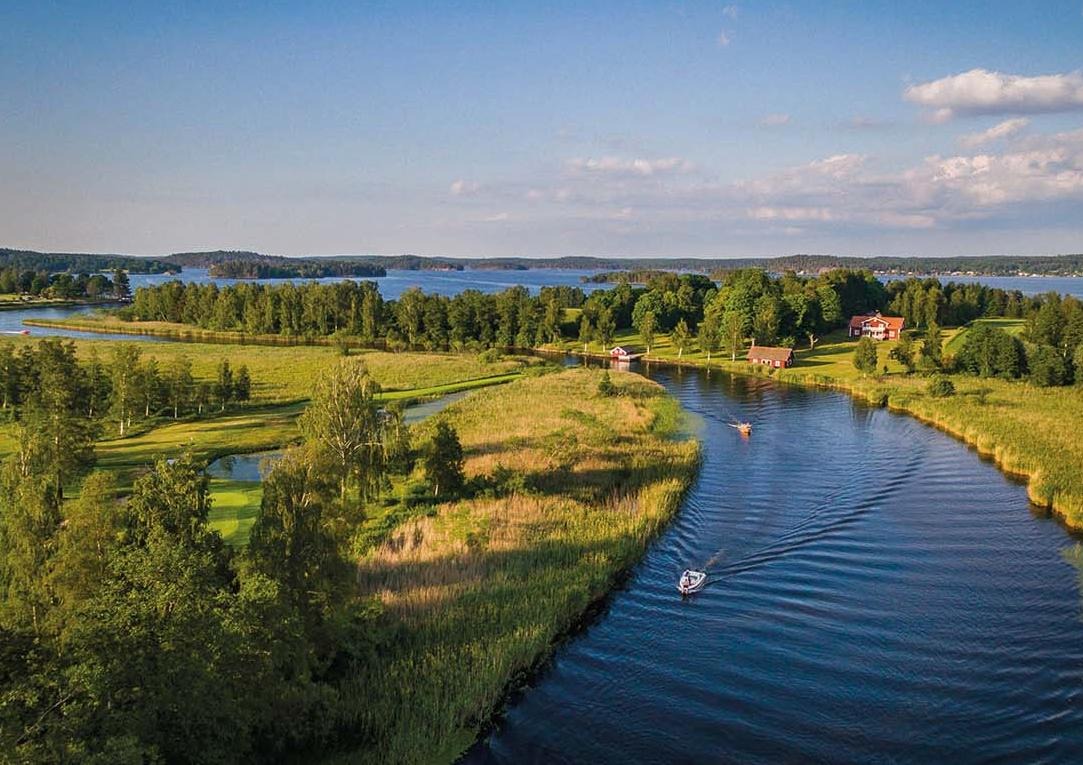 Grönskande landskap omger en åmynning
