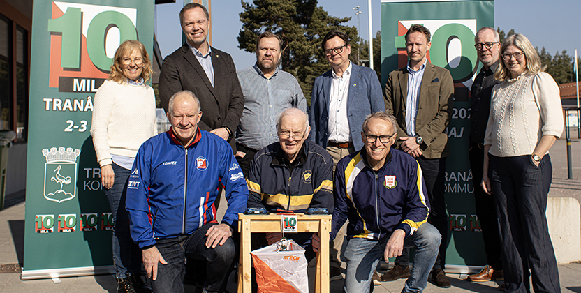 En grupp personer framför tiomila-rolluper, några med träningskläder på sig.