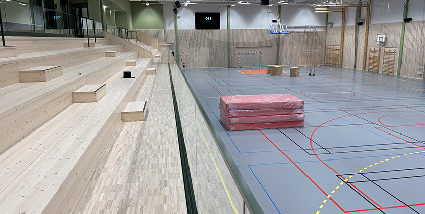 Gympasal med basketkorgar och annan idrottsinredning.