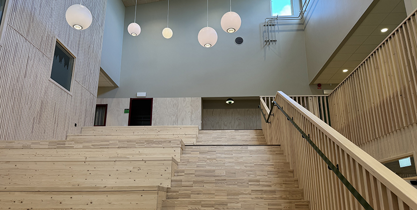 Bred trappa i trä upp till en övervåning.