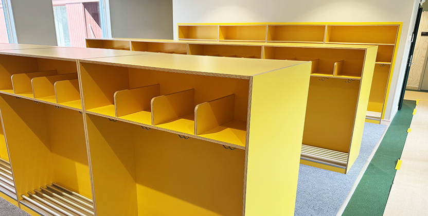 Kapprum med gula klädhyllor.